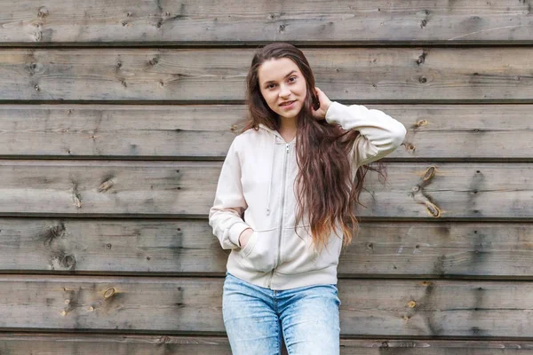 Lycklig tjej leende. Skönhet porträtt Young Happy positiv skrattande brunett kvinna på trä vägg bakgrund — Stockfoto