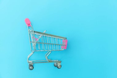 Mavi Pastel renkli arka planda izole küçük süpermarket bakkal oyuncak Push cart