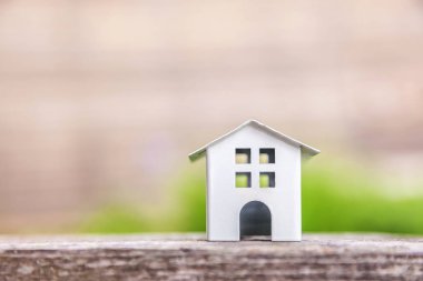 Yeşil zemin yakın ahşap arka planda minyatür beyaz oyuncak model ev