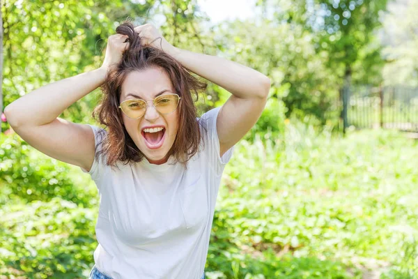 Menina feliz sorrindo. Beleza retrato jovem feliz positivo rindo morena mulher na moda óculos de sol amarelos no parque ou jardim fundo — Fotografia de Stock