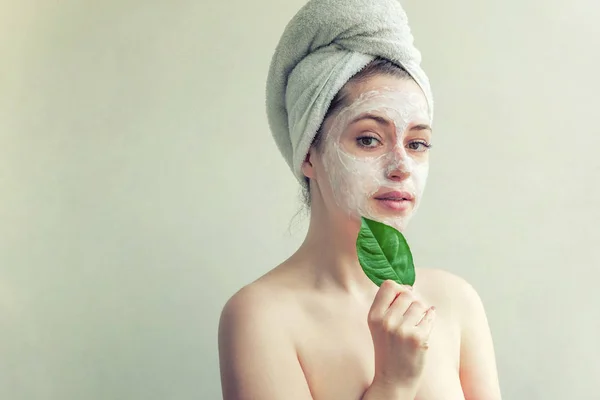 Woman face with green leaf and cream or nourishing mask — Stock Photo, Image