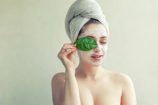 Cara de mulher com folha verde e creme ou máscara nutritiva — Fotografia de Stock