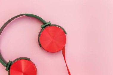 Pembe pastel renkli arka plan üzerinde izole kablo ile kırmızı kulaklıklar