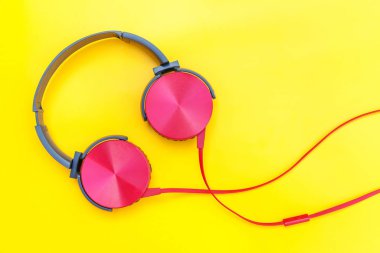 Sarı renkli arka planda izole edilmiş kablolu kırmızı kulaklıklar