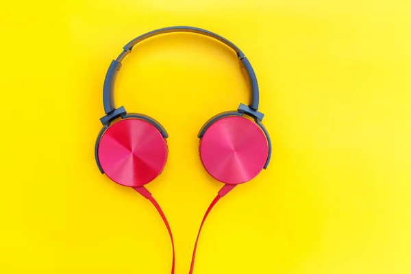 Fones de ouvido vermelhos com cabo isolado no fundo colorido amarelo — Fotografia de Stock