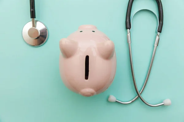 Medicine doctor equipment stethoscope or phonendoscope and piggy bank isolated on trendy pastel blue background