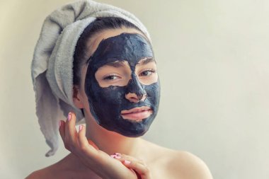 Kadının yüzündeki siyah besleyici maske uygulamak