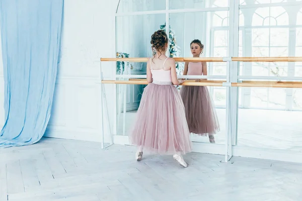 Bela graciosa bailarina praticar posições de balé na saia de tutu rosa na aula de dança — Fotografia de Stock