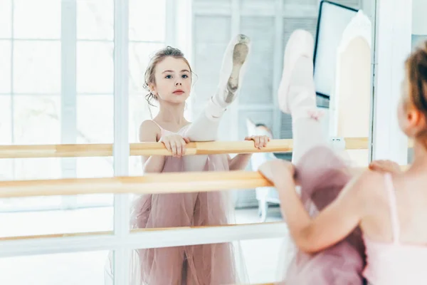 Belle ballerine gracieuse pratique des positions de ballet en jupe tutu rose en classe de danse — Photo