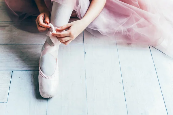 Bailarina manos pone zapatos puntiagudos en la pierna en clase de baile —  Fotos de Stock