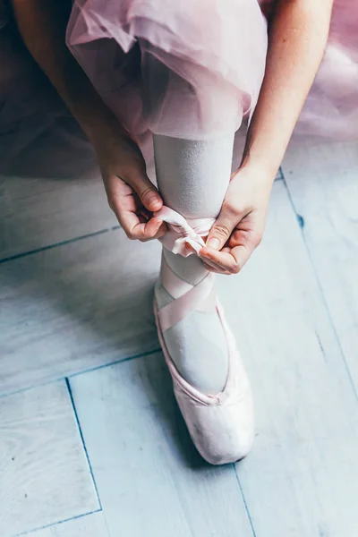 Ballerine mains met pointes chaussures sur la jambe en classe de danse — Photo