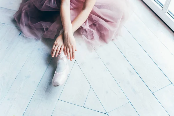 Bailarina manos pone zapatos puntiagudos en la pierna en clase de baile —  Fotos de Stock