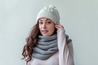 Beyaz arka planda izole sıcak giysiler şapka ve eşarp giyen Gülen kız