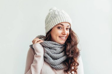 Beyaz arka planda izole sıcak giysiler şapka ve eşarp giyen Gülen kız