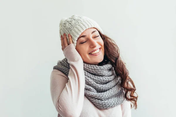 Смеющаяся девушка в теплой одежде шляпа и шарф на белом фоне — стоковое фото