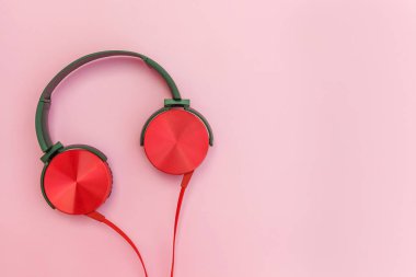 Pembe pastel renkli arka plan üzerinde izole kablo ile kırmızı kulaklıklar