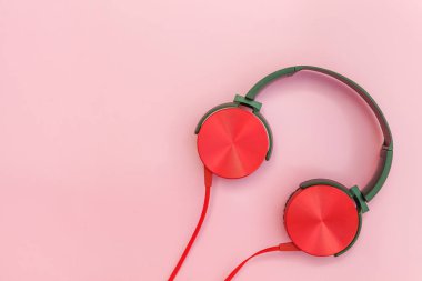 Pembe pastel renkli arka plan üzerinde izole kablo ile kırmızı kulaklıklar