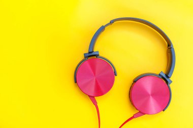 Sarı renkli arka planda izole edilmiş kablolu kırmızı kulaklıklar