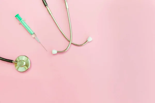 Equipamento de medicina estetoscópio ou seringa de fonendoscópio isolado em fundo rosa pastel na moda — Fotografia de Stock