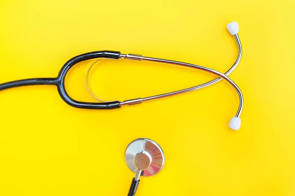 Equipo médico estetoscopio o fonendoscopio aislado sobre fondo amarillo de moda — Foto de Stock