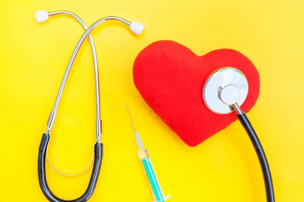 Medicine equipment stethoscope or phonendoscope syringe and red heart isolated on trendy yellow background — Stock Photo, Image