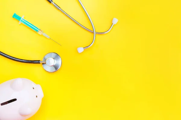 Medicina equipamento médico estetoscópio ou fonendoscópio piggy bank seringa isolada no fundo amarelo da moda — Fotografia de Stock
