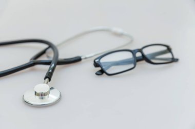 Tıbbi ekipman stetoskop veya fonndoskop ve gözlük beyaz arka plan üzerinde izole. Doktor için alet cihazı. Sağlık hayat sigortası kavramı