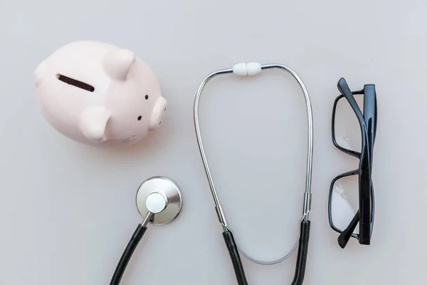 Medicine doctor equipment stethoscope or phonendoscope piggy bank glasses isolated on white background