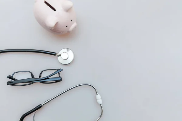Medicine doctor equipment stethoscope or phonendoscope piggy bank glasses isolated on white background