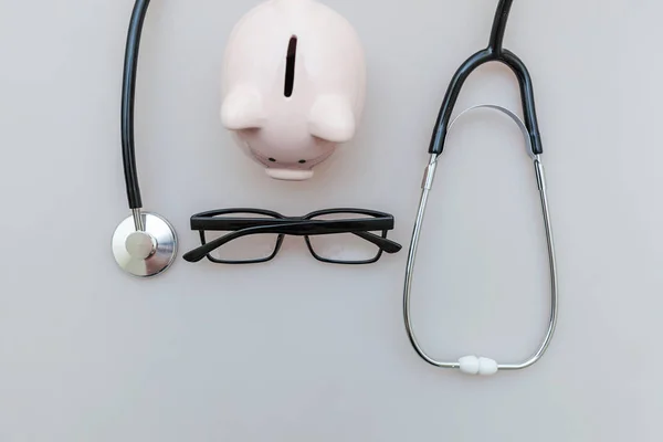 Medicine doctor equipment stethoscope or phonendoscope piggy bank glasses isolated on white background