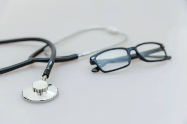 Equipo de medicina estetoscopio o fonendoscopio y gafas aisladas sobre fondo blanco. Instrumento para médico. Concepto de seguro de vida de salud — Foto de Stock