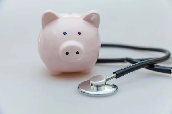 Medicina equipamento médico estetoscópio ou fonendoscópio e porquinho banco isolado em fundo branco — Fotografia de Stock