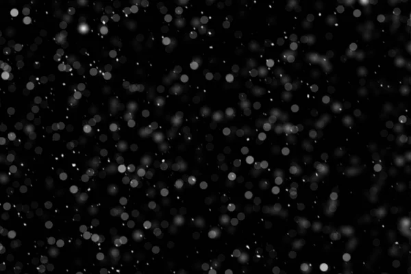 Falling down real white snowflakes on black background