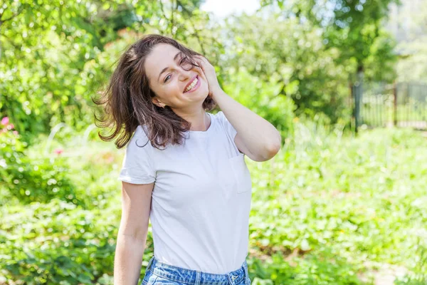 Menina feliz sorrindo. Retrato de beleza jovem feliz positivo rindo morena mulher no parque ou jardim fundo — Fotografia de Stock