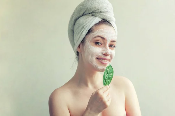 Woman face with green leaf and cream or nourishing mask — Stock Photo, Image