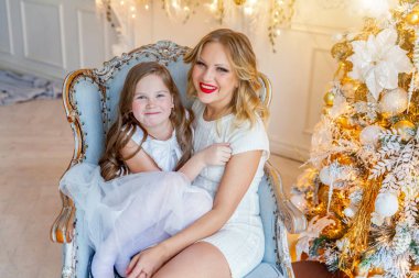 Anne ve kızı evde Noel ağacı yakınında oynarken dinlenmek