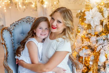 Anne ve kızı evde Noel ağacı yakınında oynarken dinlenmek