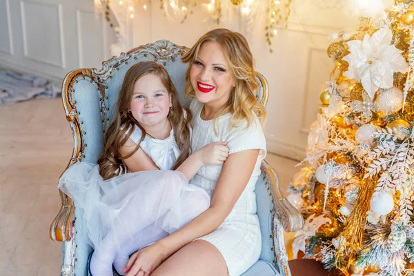 Anne ve kızı evde Noel ağacı yakınında oynarken dinlenmek