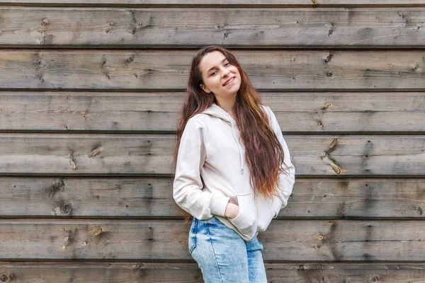 Lycklig tjej leende. Skönhet porträtt Young Happy positiv skrattande brunett kvinna på trä vägg bakgrund — Stockfoto