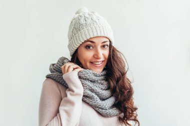 Beyaz arka planda izole sıcak giysiler şapka ve eşarp giyen Gülen kız