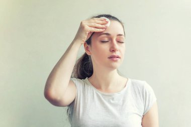 Yumuşak sağlıklı cilt kaldırarak gülümseyen kadın beyaz arka plan üzerinde izole pamuk ped ile makyaj