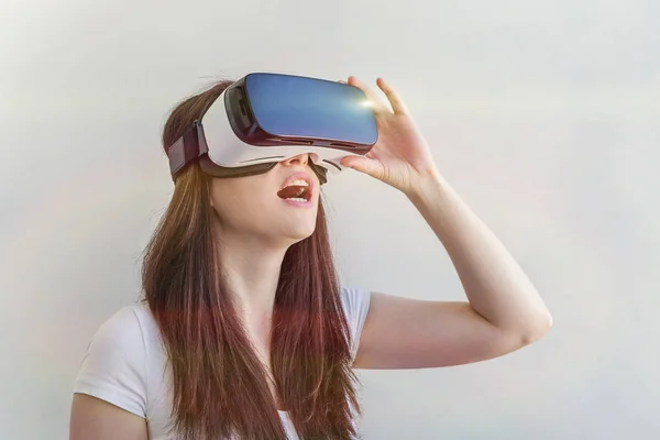 Sorria jovem vestindo usando realidade virtual óculos VR capacete headset no fundo branco — Fotografia de Stock