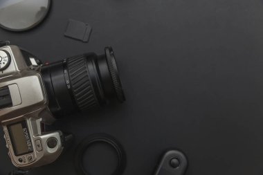 DSLR kamera sistemi, kamera Temizleme Kiti, koyu siyah masa arka planda objektif ve kamera aksesuarı ile fotoğrafçı çalışma alanı
