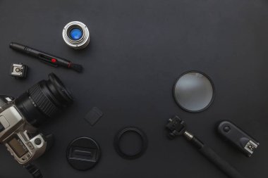 DSLR kamera sistemi, kamera Temizleme Kiti, koyu siyah masa arka planda objektif ve kamera aksesuarı ile fotoğrafçı çalışma alanı