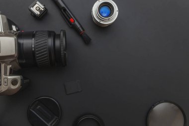 DSLR kamera sistemi, kamera Temizleme Kiti, koyu siyah masa arka planda objektif ve kamera aksesuarı ile fotoğrafçı çalışma alanı