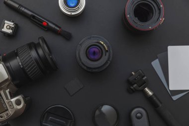 DSLR kamera sistemi, kamera Temizleme Kiti, koyu siyah masa arka planda objektif ve kamera aksesuarı ile fotoğrafçı çalışma alanı