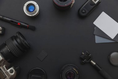 DSLR kamera sistemi, kamera Temizleme Kiti, koyu siyah masa arka planda objektif ve kamera aksesuarı ile fotoğrafçı çalışma alanı