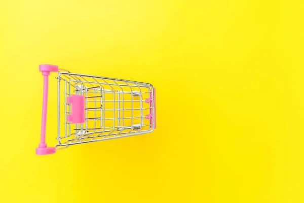 Pequeño supermercado supermercado juguete empuje carro aislado sobre fondo de color amarillo — Foto de Stock