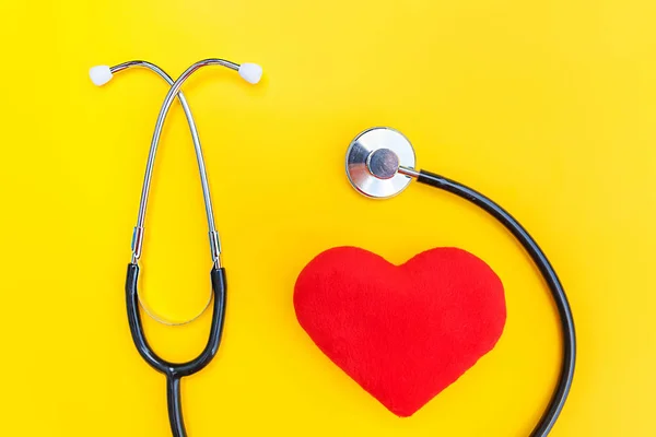 Equipamento de medicina estetoscópio ou fonendoscópio e coração vermelho isolado no fundo amarelo da moda — Fotografia de Stock