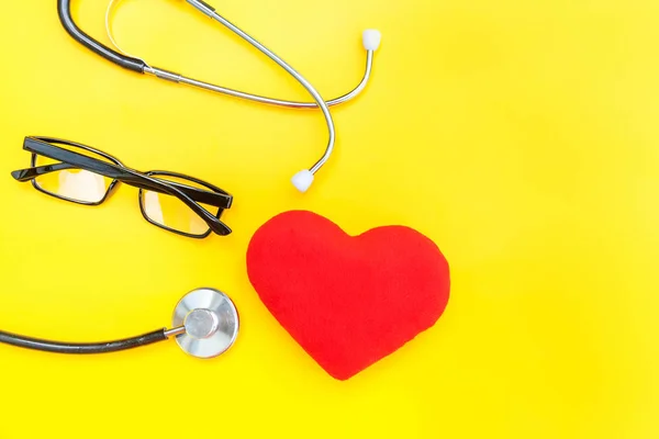 Estetoscopio o gafas de fonendoscopio y corazón rojo aislados sobre fondo amarillo de moda — Foto de Stock